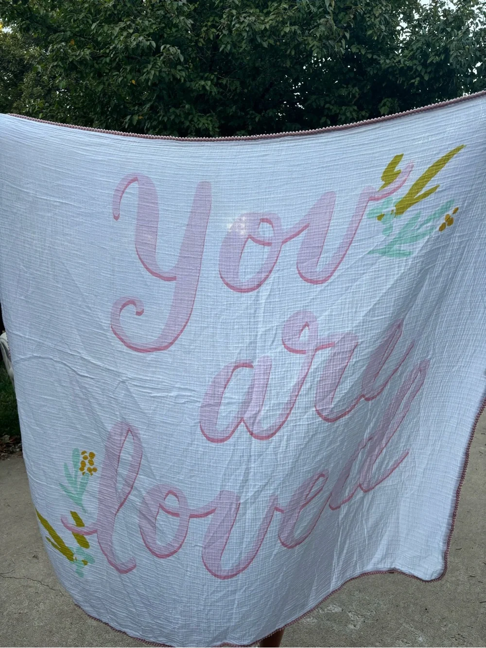 You Are Loved Pink Script Muslin Baby Blanket has a light stain
